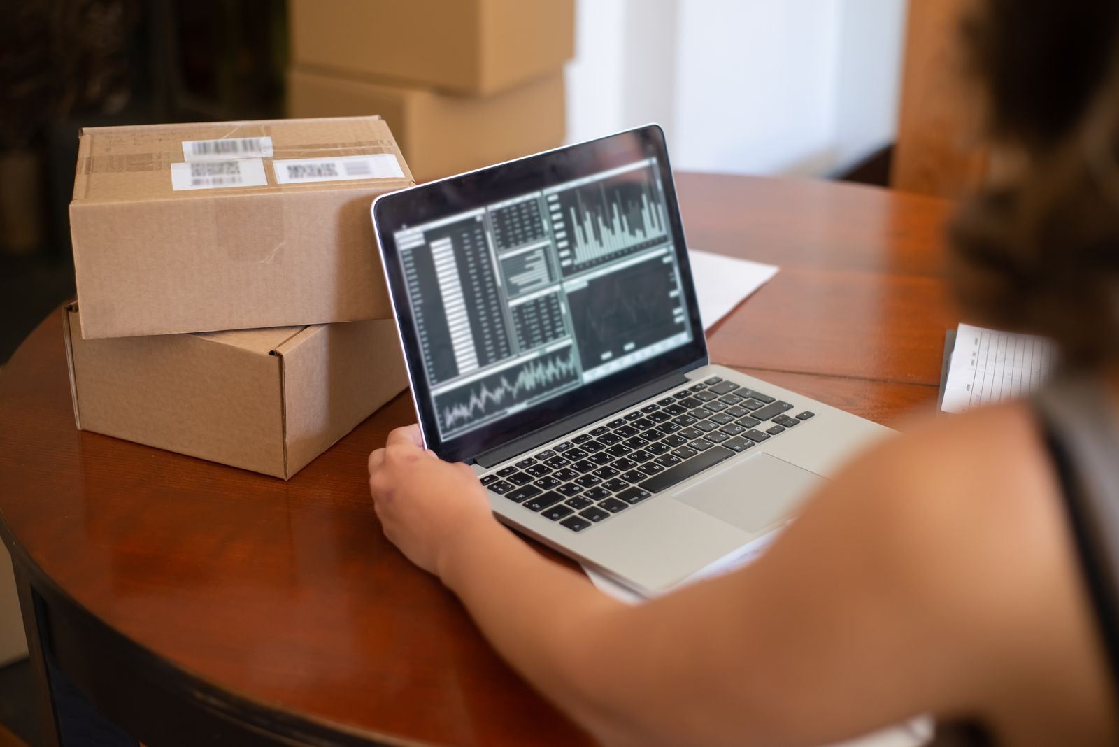 bol.com verkoper beheert online bestellingen vanaf een laptop tussen verzenddozen